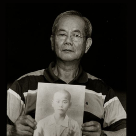 黃忠義手持兄長黃藍雄遺照