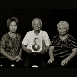 尤萬居家屬手持其遺照